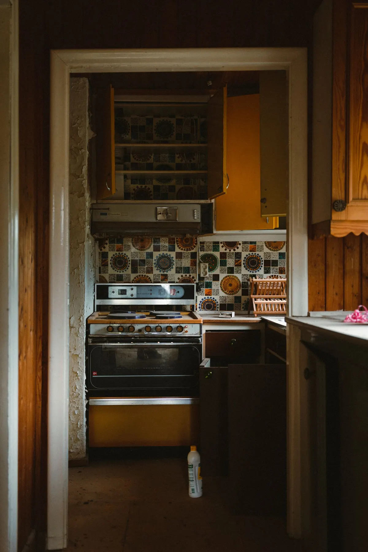 Before: dated 1970s kitchen with yellow cabinets and retro tile