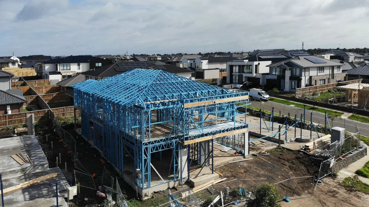 Aerial view of a home addition under construction with steel framework